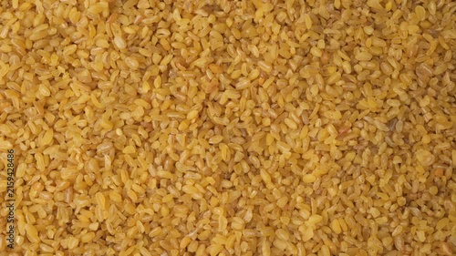 Raw bulgur wheat groats background texture