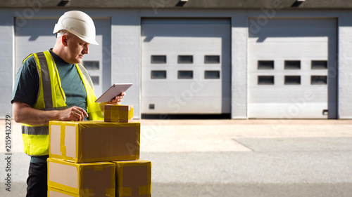 Warehouse logistics. Shipping supervisor verifies outgoing parcels with a tablet at a loading dock, managing dispatch, package tracking and warehouse distribution.