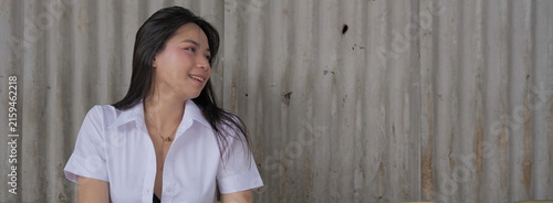Canvas Print A candid, wide-angle shot of a smiling young Asian woman in a white uniform shir
