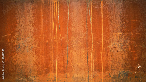 Close-up of textured orange rust surface with vertical streaks and weathered metallic finish
