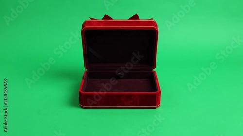Realistic red gift box open with ribbon on green background.