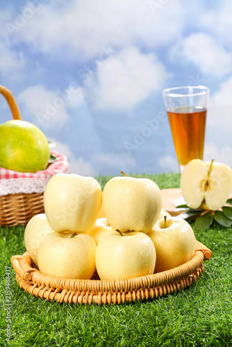 Fresh Golden Fuji Apples in Wicker Basket Outdoor Picnic Scene with Apple Juice