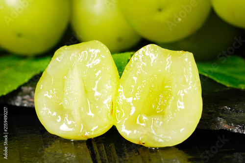 Quadro su tela Fresh Seedless Green Grapes Cut in Half Showing Juicy Interior with Leaves