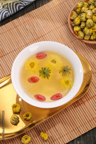 Fotografie Traditional Chrysanthemum Flower Tea with Dried Blooms and Goji Berries on Bambo