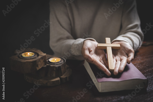 Fotografie A religious woman praying with a cross indoors, showing devotion, faith, love, hope, comfort, and a deep connection with God