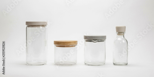 Assorted glass jars with wooden and metal lids on a clean white background