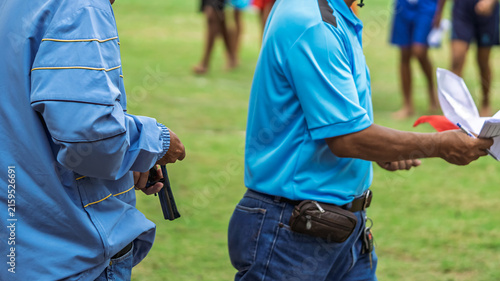 Photography Referee checking starting pistol revolver for sports competition