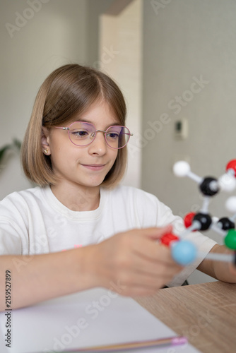 science and child with atom model for project, discovery or assignment. STEM education. Elementary science student using plastic atom model educational toy. 