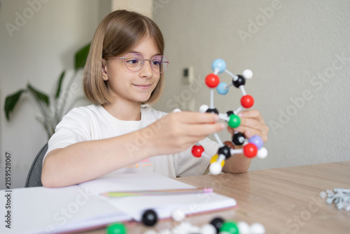 science and child with atom model for project, discovery or assignment. STEM education. Elementary science student using plastic atom model educational toy. 