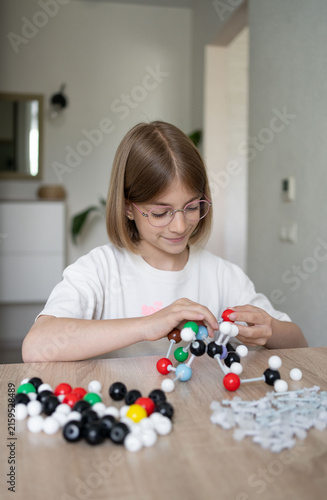 girl making molecular model learning chemistry science, home education. STEM 