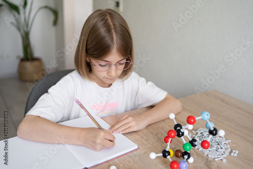 science and child with atom model for project, discovery or assignment. STEM education. Elementary science student using plastic atom model educational toy. 