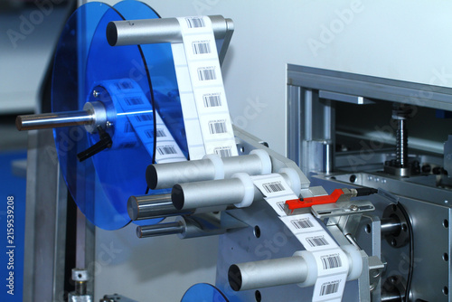 Foto Automatic barcode label roll on industrial labeling machine in factory