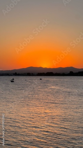 sunset over the sea
a vibrant, golden-hour sunset over a calm coastal body of water, resembling scenic Mediterranean in Hammamet, Tunisia.
