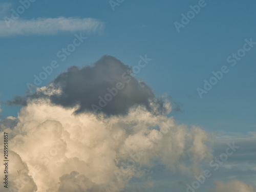 Dynamic clouds featuring bright white cumulus bases overlaid with darker cloud fragments ranging from slate gray to near-black.