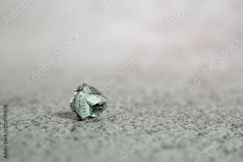 Crumpled money on the floor with blurry foggy background. Dismal economics condition concept.