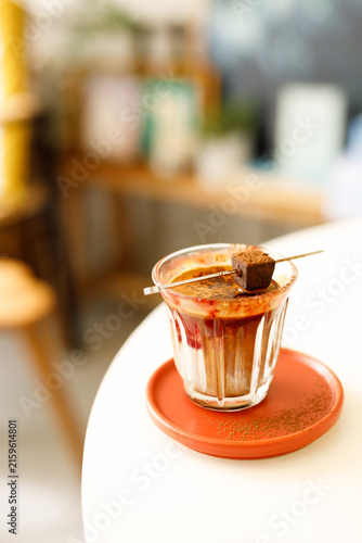 Glass of layered milk latte by the window.