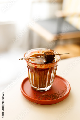 Glass of layered milk latte by the window.