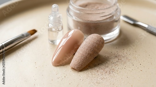 Nude nail art tips with acrylic powder and brush on a tray. gel vs dip nails