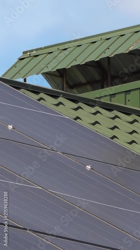 Solar panels installed on the roof of a city building. Concept of eco friendly and alternative power source - Vertical Video