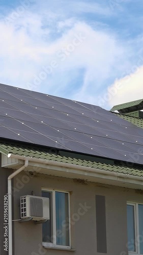 Solar panels installed on the roof of a city building. Concept of eco friendly and alternative power source - Vertical Video