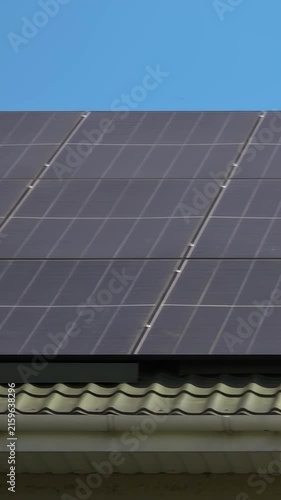 Solar panels installed on the roof of a city building. Concept of eco friendly and alternative power source - Vertical Video