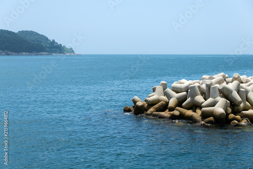 Konstfotografi Scenic Coastal View with Green Forested Headland and Tetrapod Breakwater