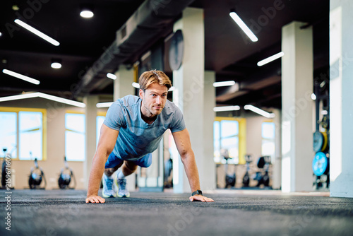 Fotografía Man doing pushups on the gym floor, focusing on physical fitness, strength, and