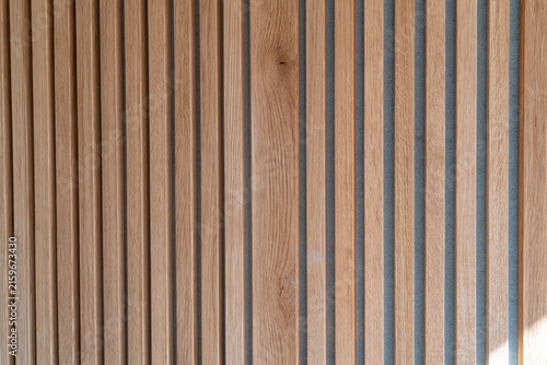 Vertical timber slat panelling with a tactile wood grain and blue acoustic backing, creating a calm textured surface for interior design and material libraries
