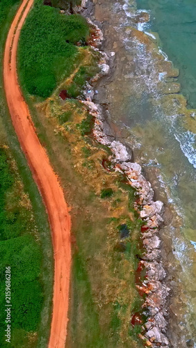 Foto Aerial view captures the rugged coastline where verdant dunes meet the crashing waves