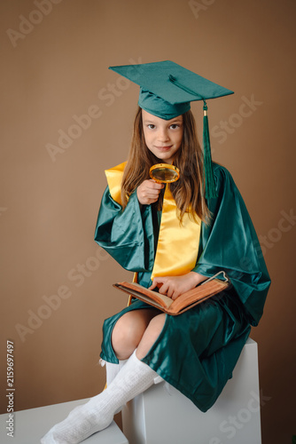 Bild auf Leinwand Young girl exploring knowledge with magnifying glass