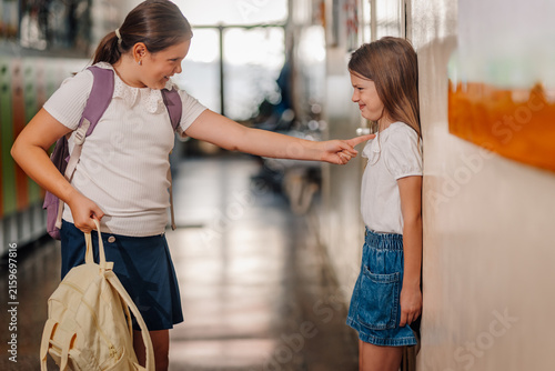 Obraz na plátne Girl bullying another girl in school hallway