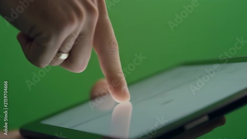 A close-up shot of a hand interacting with a tablet screen.