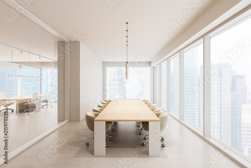 Fotografía Bright modern office conference room with long wooden table, rolling chairs, glass walls, panoramic windows, and skyline views