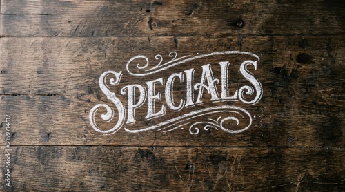 Specials Sign Written in White Chalk on Dark Rustic Weathered Wooden Planks Background for Restaurant Menu Promotion or Retail Shop Sales Announcement