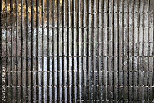 Glossy black tile vertical ribbed wall surface background for professional interior design presentation.