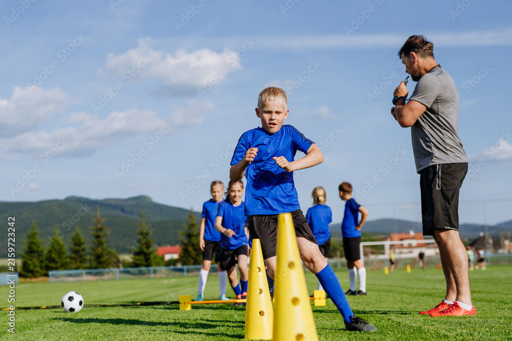 Naklejka premium Young athletes training footwork and coordination on soccer field.