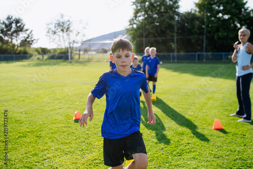 Картината върху платно Young athletes training footwork and coordination on soccer field