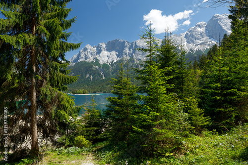 Travel landscape of Zugspitze Alps in Bavaria, Germany, scenic summer nature panorama with forest, Eibsee lake, snow mountains peak. Alpine landscape