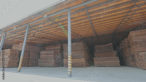 Air-drying and storage of wooden boards under a canopy at a furniture factory. Drying of stacked timber at a sawmill's lumber yard.