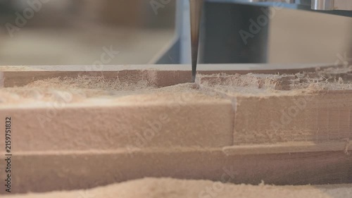 Wooden furniture factory and manufacture. Close-up of CNC machine cutting and shaping a wooden furniture part. CNC machine cutting a decorative shape in a wooden part.