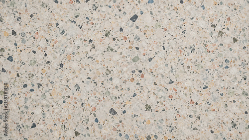 Close-up view of a textured concrete surface with various colored aggregate specks, creating a rough and granular pattern.