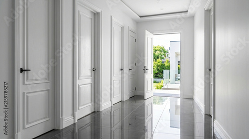 Modern Hallway with Multiple White Doors and Open Entrance to Garden