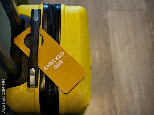 Reykjavik, Iceland - May 09, 2026: Yellow hard-shell suitcase with a checked-out tag attached, showcasing a modern design suitable for travel and luggage storage