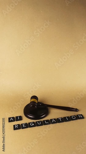 Conceptual video showing letter tiles spelling AI Regulation next to a wooden judge's gavel on a neutral background, representing legal oversight of new artificial intelligence technology
