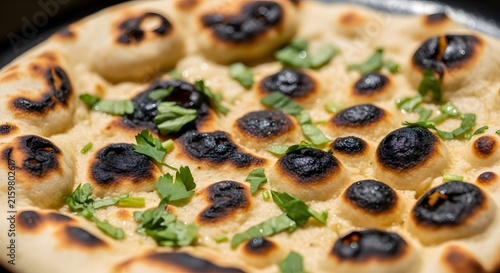 Deliciously Charred Naan Bread with Fresh Green Herbs Sprinkled on Top.