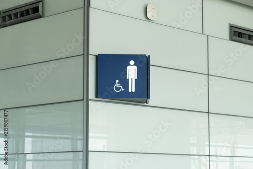 sign with man symbol marking restroom in public building. navigation sign showing wheelchair access for disabled visitors. concept of sign system and accessible environment in modern space