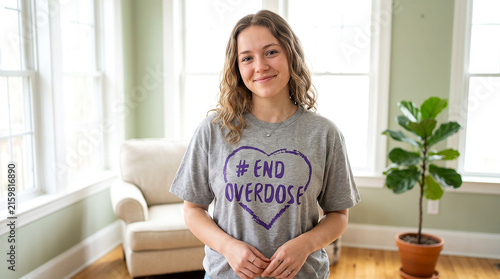 Smiling young woman supporter standing indoors wearing t-shirt with End Overdose message for overdose awarness day advocacy campaign