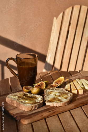 Rustic Mediterranean breakfast with figs, honey and cheese served on a terrace