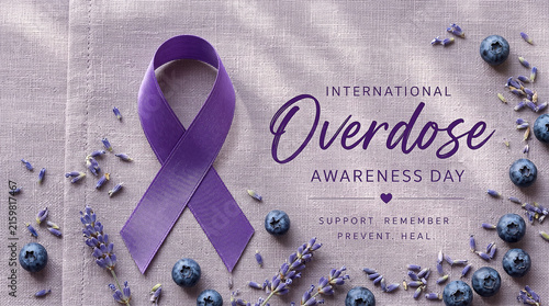 Purple ribbon on textured linen napkin with lavender and blueberries flat lay concept for international overdose awareness day campaign