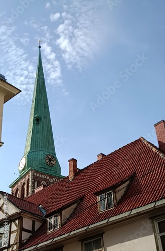 Cuadro en lienzo Green church spire steeple above old town red tile roofs